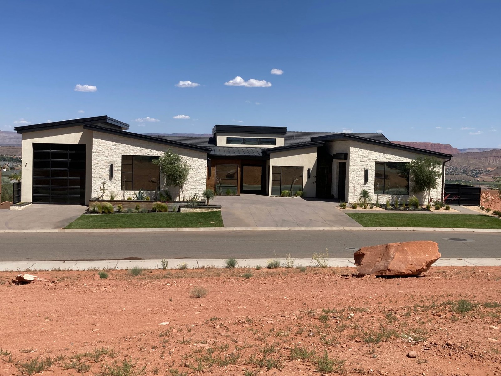 A large house with a lot of windows sits on the side of a road