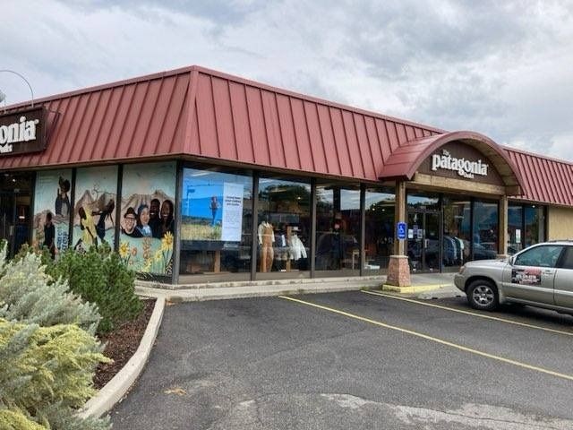 A storefront with a car parked in front