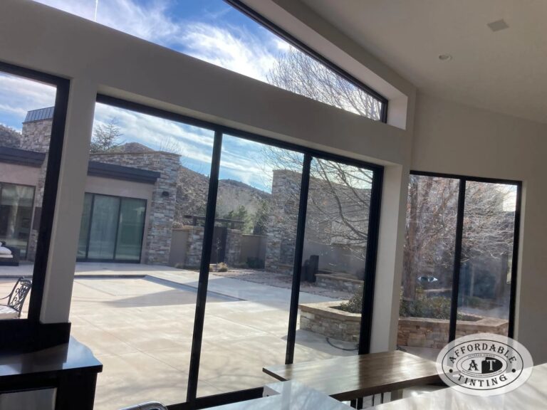 Low-angle sunlight through tall residential windows treated with window film